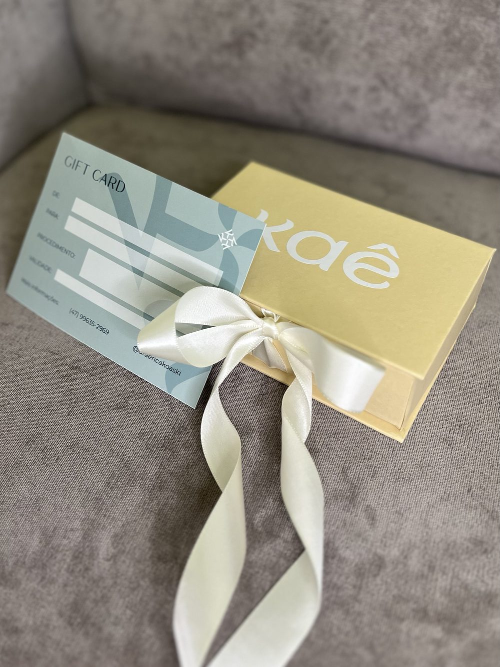 Caixa Kaê com laço de cetim e gift card.