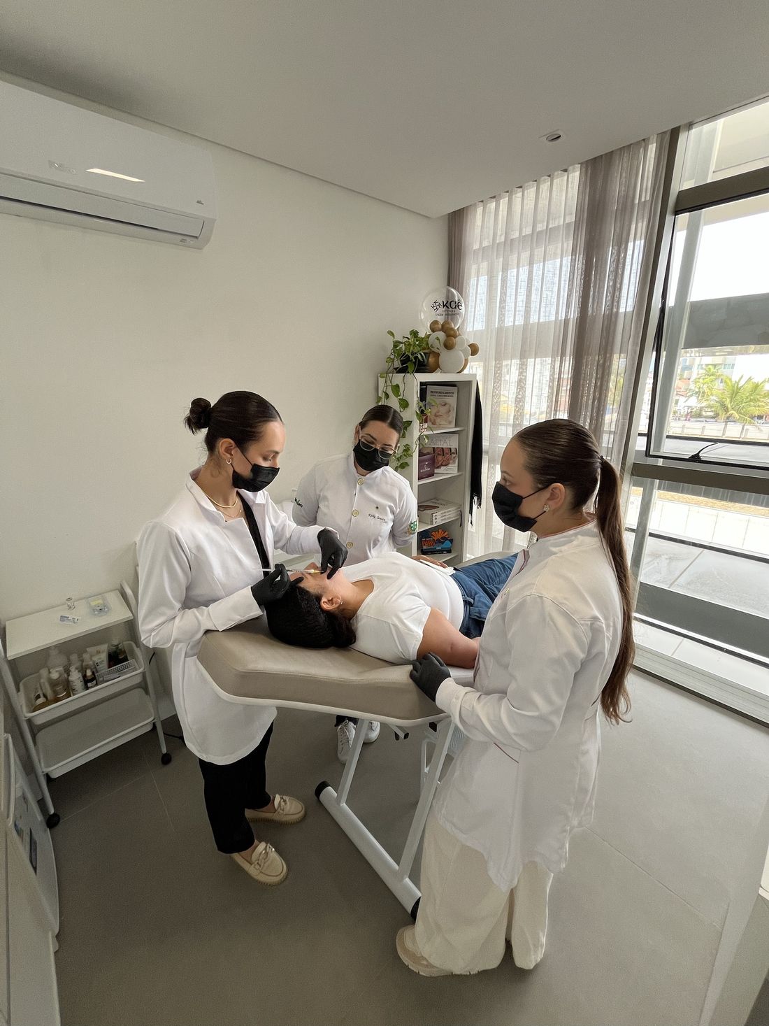 Dra. Érica orientando alunas durante a prática com paciente modelo.