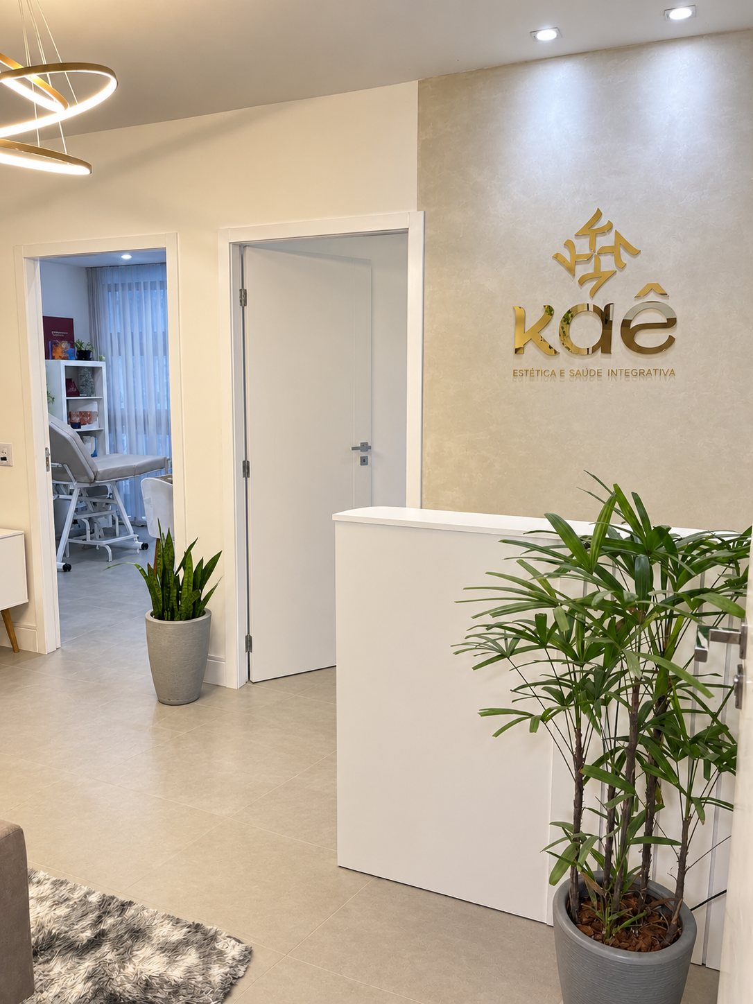 Recepção da Kaê, com o logotipo dourado na parede.